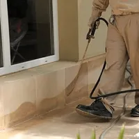 General pest control technician spraying exterior perimeter around a home in South Bend, IN